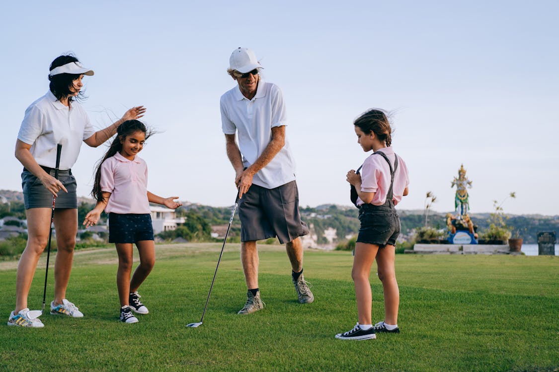 Adults golfing with children.